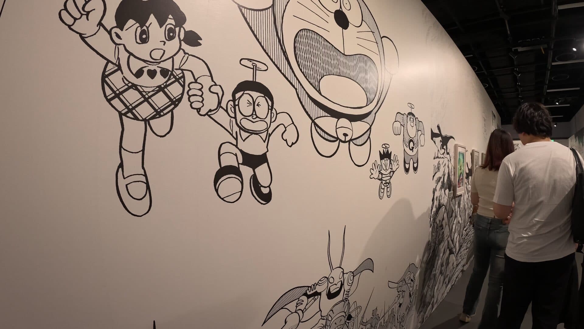 Black-and-white Shizuka, Nobita with the bamboo copter, and a giant Doraemon head.